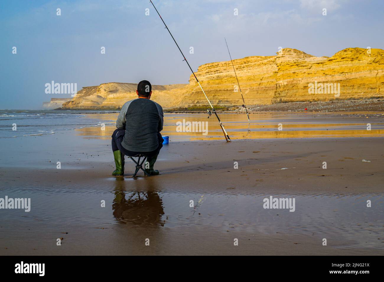 Laayoune, Marokko - 30. Juli 2022 : Ein Fischer hält und seine Angelrute Stockfoto