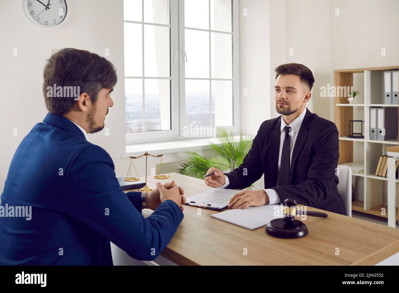 Der junge Mann kommt zur professionellen Rechtsberatung in die Anwaltskanzlei oder in die Anwaltskanzlei Stockfoto
