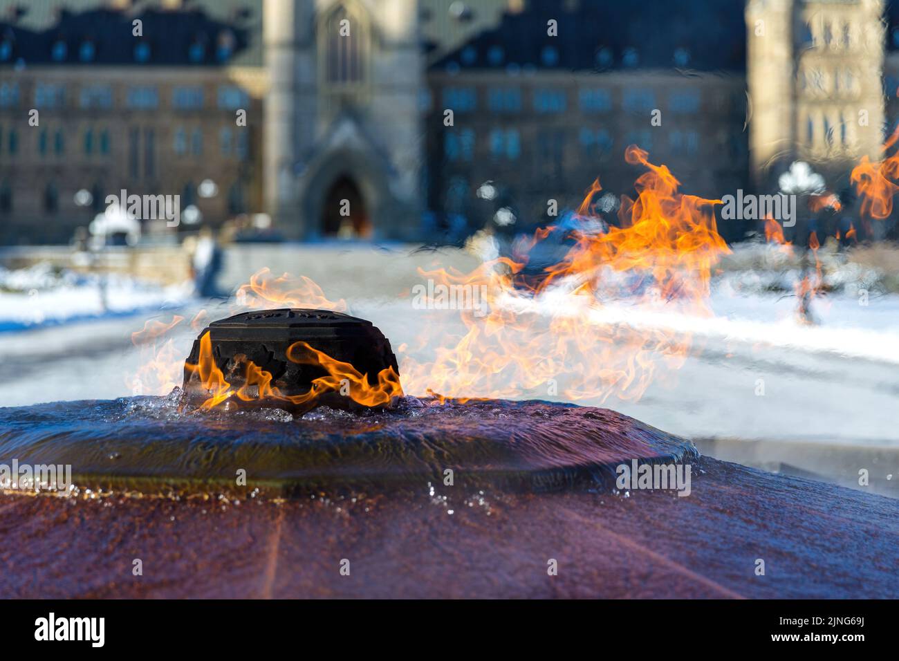 Die ewige Flamme brennt vor einem schneebedeckten kanadischen Parlamentsgebäude in Ottawa, Ontario. Es erinnert an den 100.. Jahrestag der Confed Stockfoto