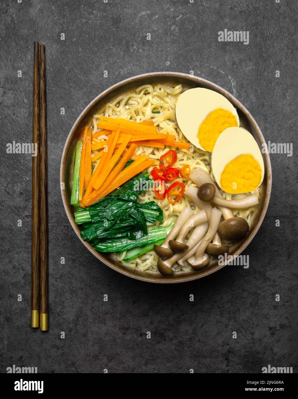 Asiatische Nudeln Suppe mit Pilzen, Eiern, dan sortiertes Gemüse auf dunklem Hintergrund. Stockfoto