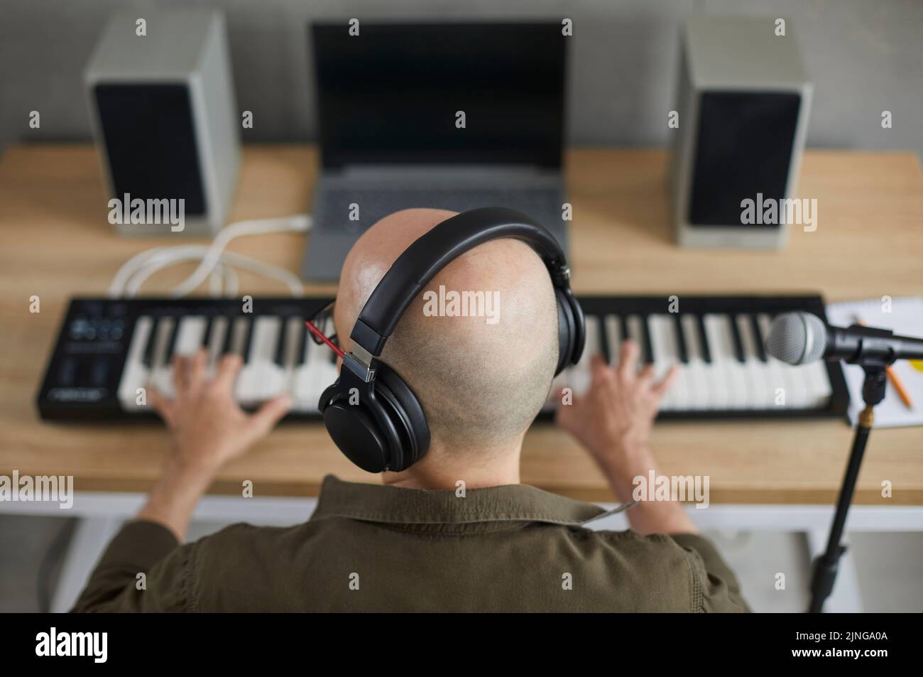 Männliche Musiker in Kopfhörern komponieren Musik auf Keyboards Stockfoto