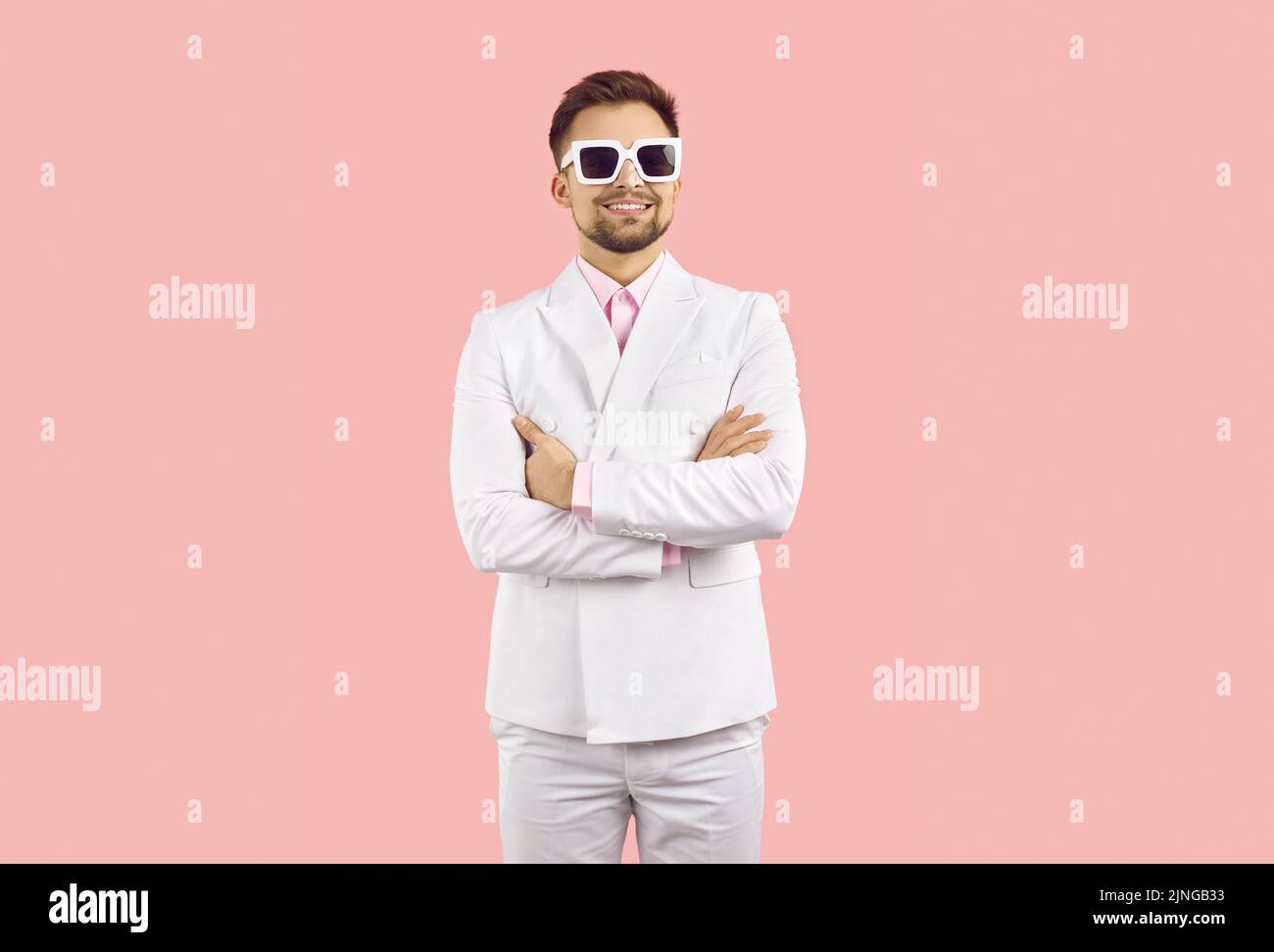 Porträt von lustigen kühlen und stilvollen jungen Mann in Anzug isoliert auf pastellrosa Hintergrund. Stockfoto