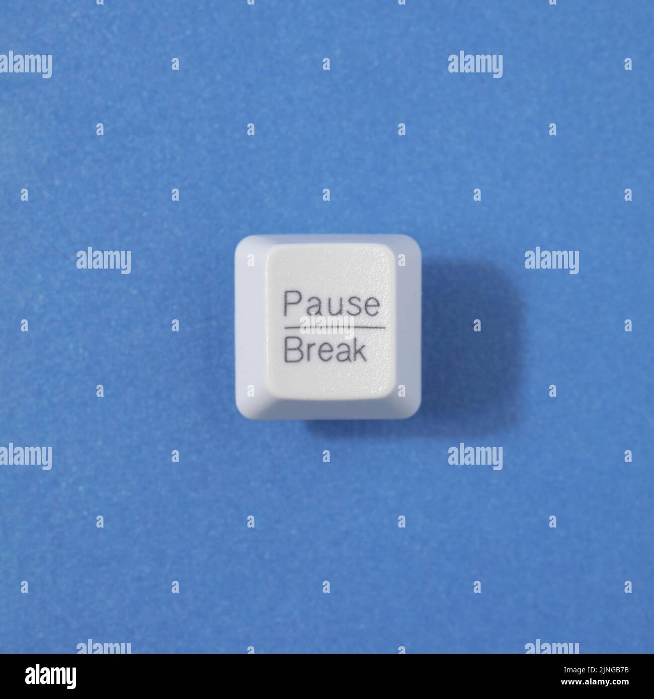 Makro für die Retro-Pause-Tastaturtaste auf blauem Hintergrund. Burnout, minimale Aussicht von oben. Stockfoto