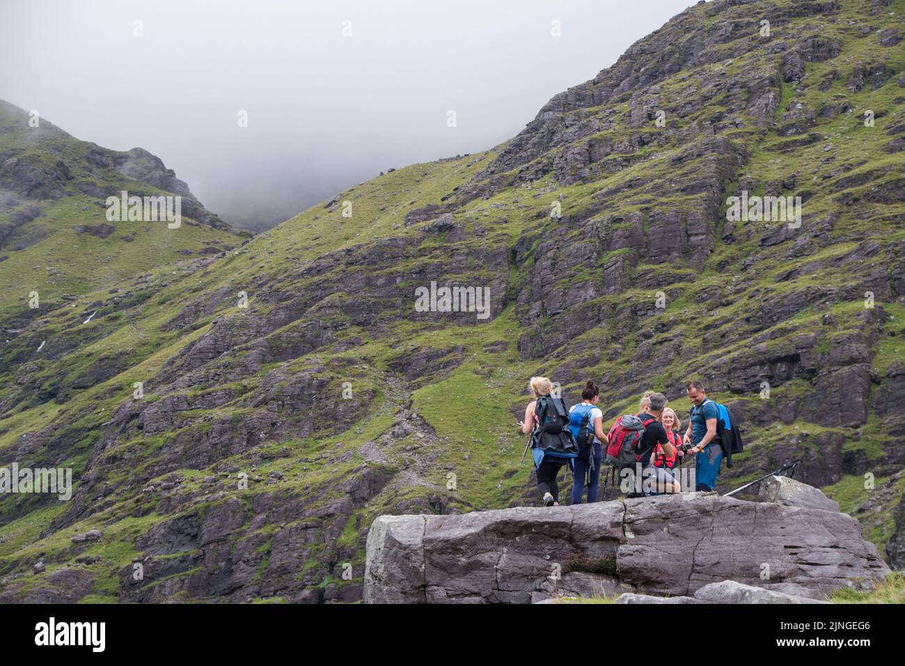 Eine Gruppe von Freunden posiert für Fotos auf dem Weg zum Caurrantoohil, Irlands höchstem Berggipfel in Irland Stockfoto