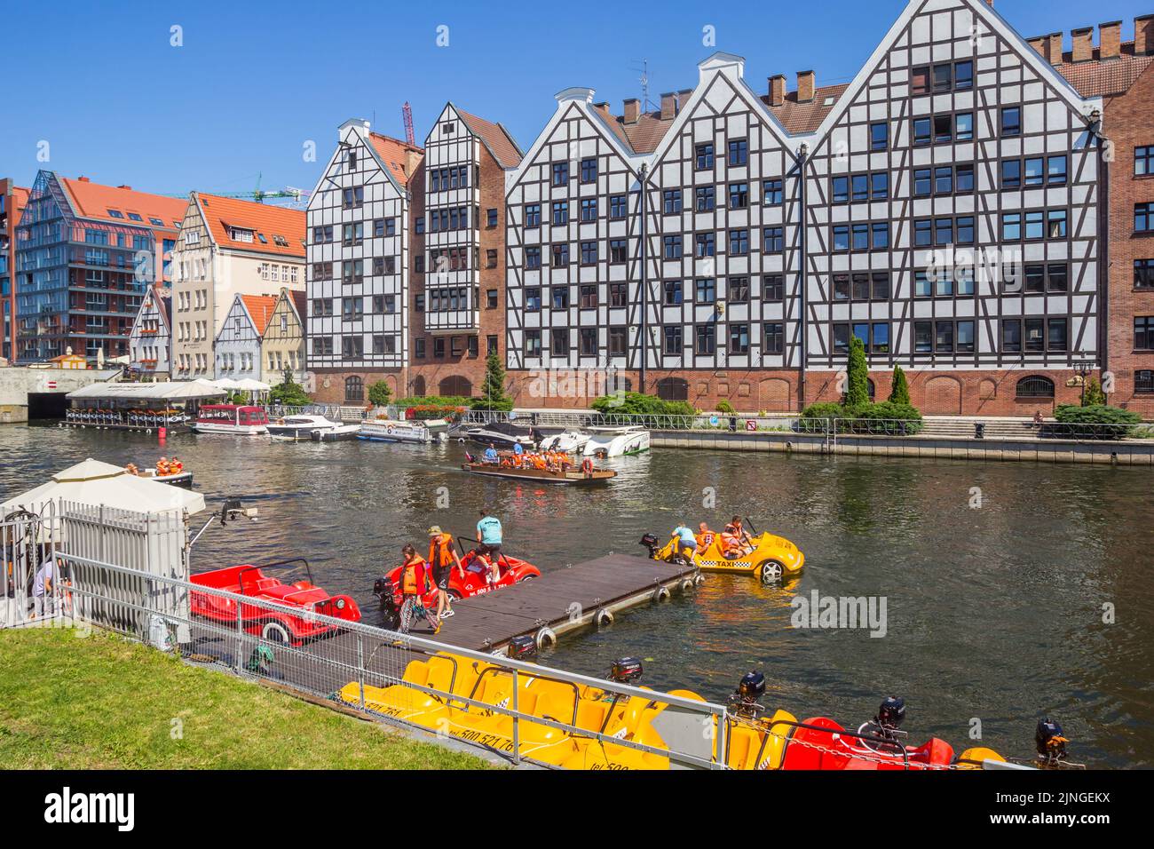 Touristen, die ein Motorboot für eine Bootsfahrt auf dem Fluss Motlawa in Danzig, Polen, bekommen Stockfoto