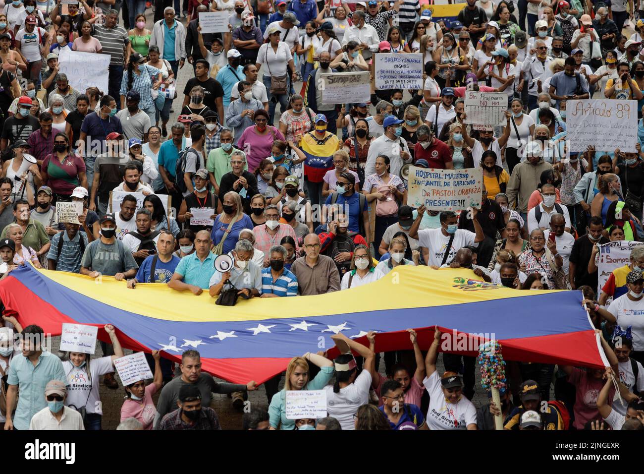 Caracas, Venezuela. 11. August 2022. Demonstranten schwenken eine große venezolanische Flagge während eines Protestes von Beschäftigten des öffentlichen Sektors für bessere Löhne. Die Proteste dauern tagelang an. Kredit: Jesus Vargas/dpa/Alamy Live Nachrichten Stockfoto