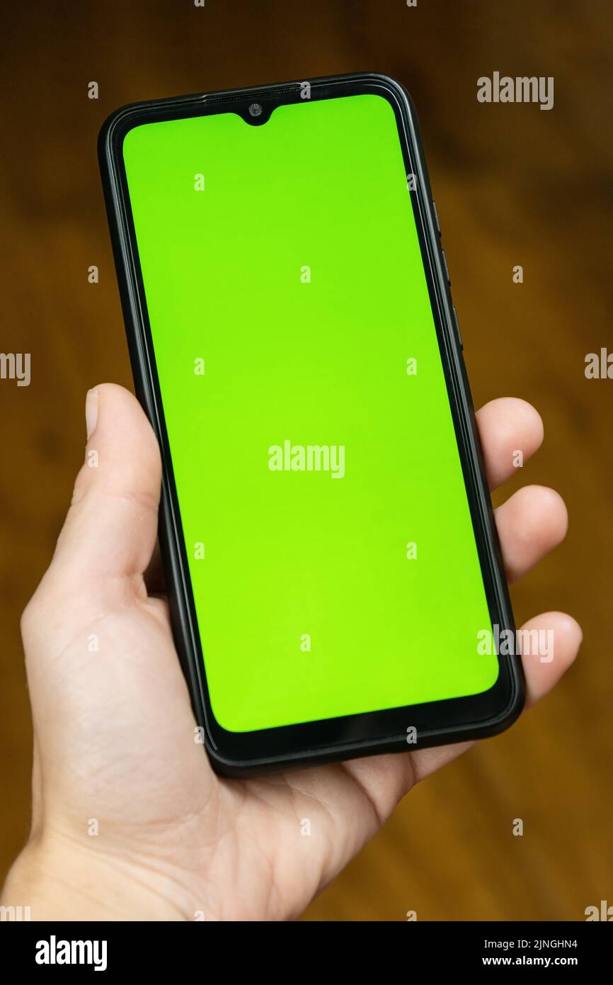 Grüne Chroma-Schlüsselhand mit Handy-Mockup-Muster. Stockfoto