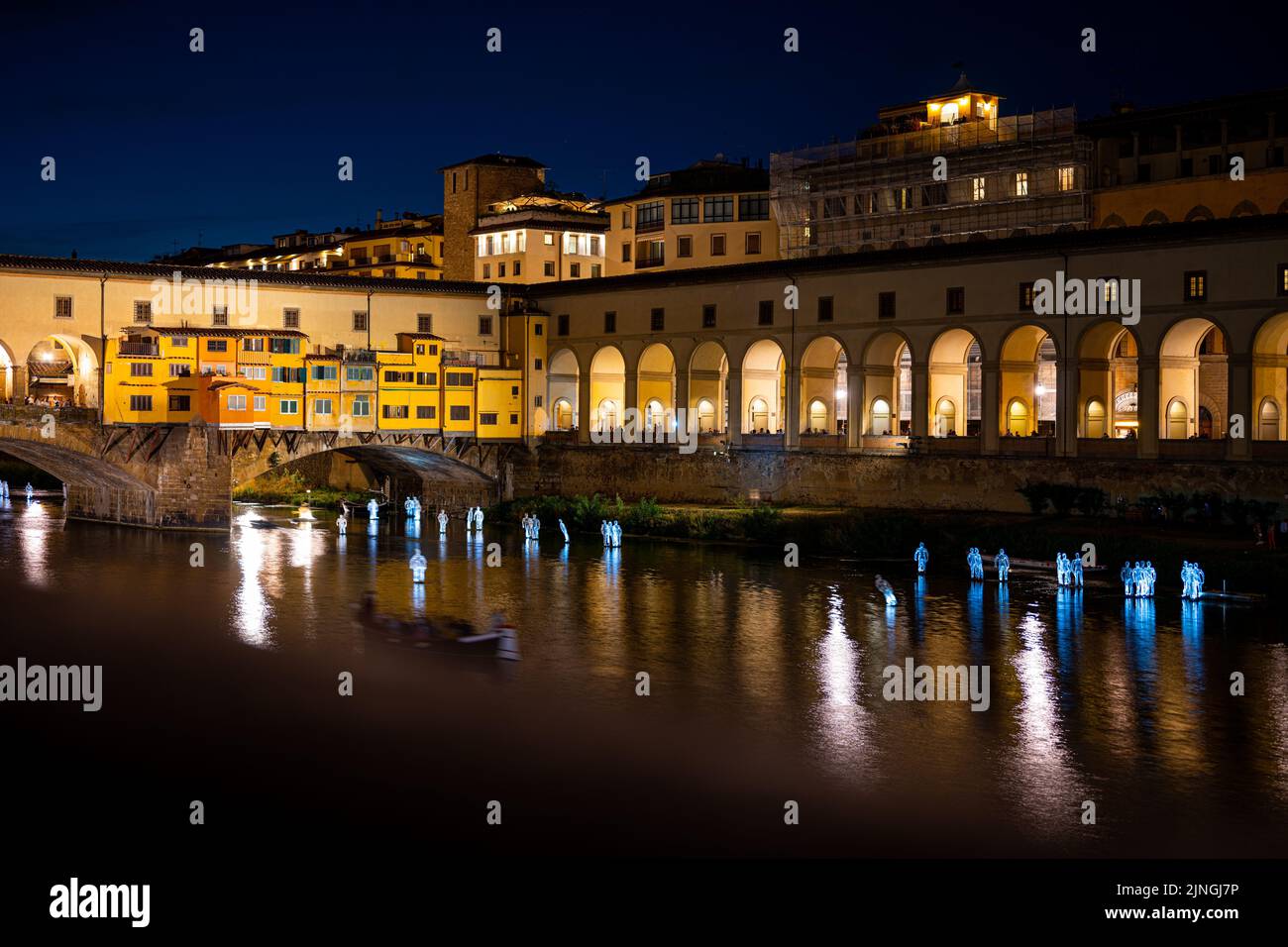 Die beleuchtete Brücke Ponte Vecchio mit den Lichtern auf einer Wasseroberfläche in der Nacht Stockfoto