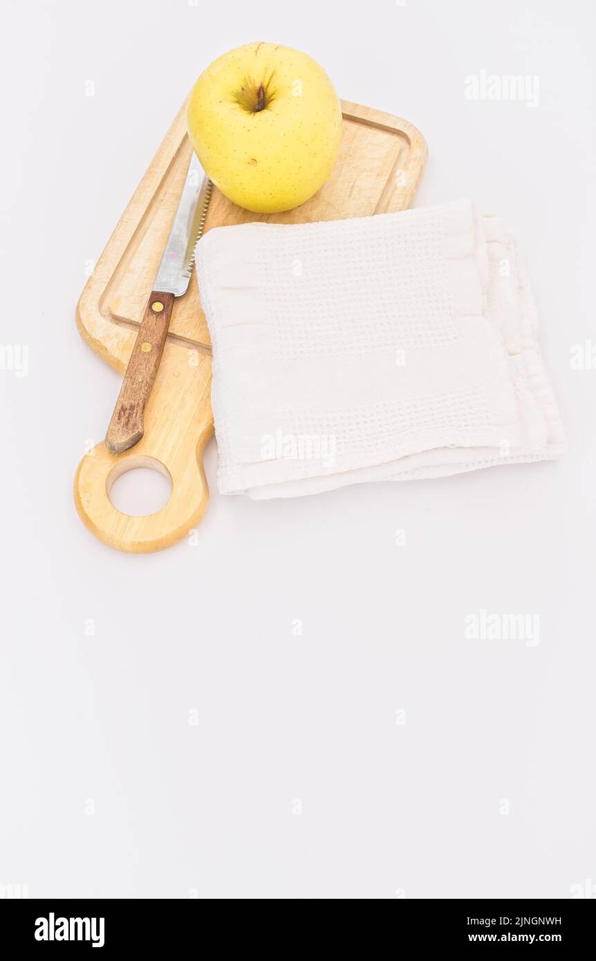 Frischer Bio-Anbau goldener Apfel auf einem Holzschneidebrett mit Messer und weißem Küchentuch Stockfoto