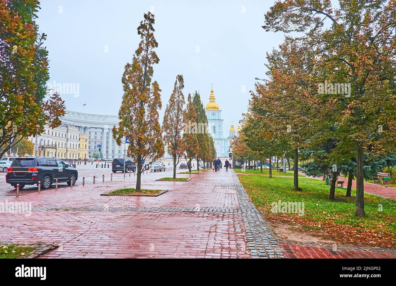 Spazieren Sie entlang der historischen Wolodymyrska-Straße, gesäumt von Herbstbäumen, mit Blick auf den Glockenturm des Klosters St. Michael's Golden Domed im Hintergrund, Kiew, Stockfoto