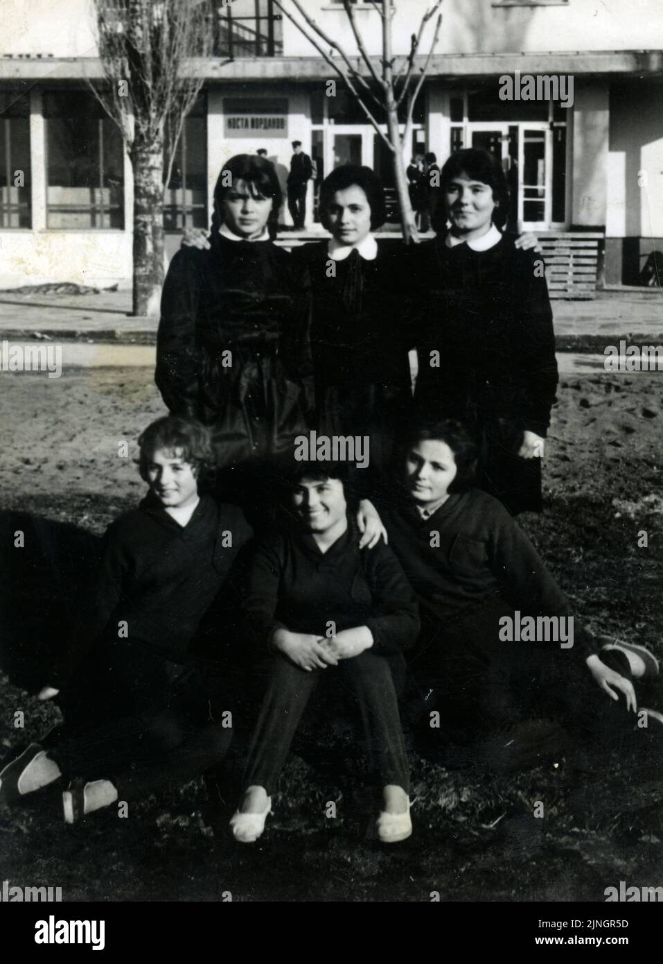 Porträt von Freundinnen Schülerinnen in schwarzen Schuluniformen posieren für Foto außerhalb ihrer Schule in der 60s, Bulgarien Stockfoto