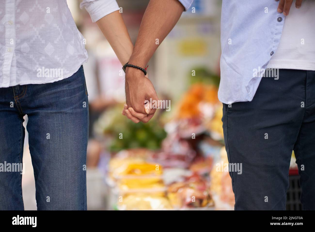 Nicht erkennbares interrassisches Paar, das die Hände im Freien hält Stockfoto