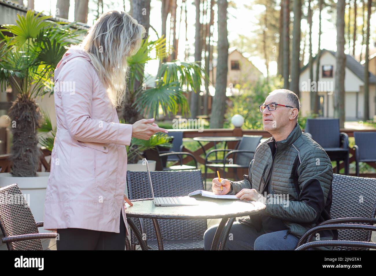 Porträt eines ernsthaften Mannes mittleren Alters Vater Notizen schreiben, hören junge Frau Tochter erklären Informationen. Stockfoto