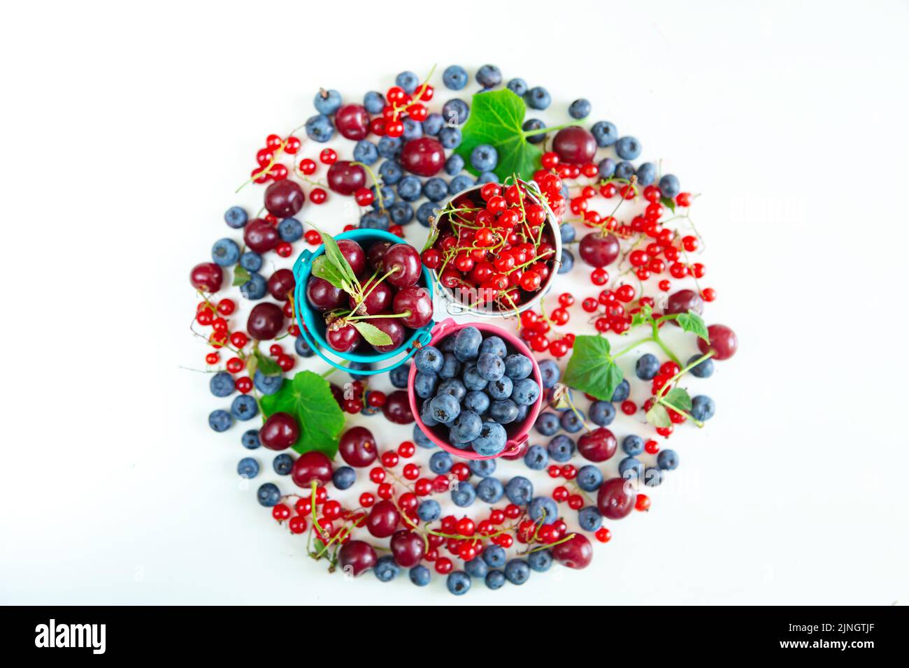 Mischen Sie frische Beeren in kleinen Eimern. Blick von oben. Saftige Sommertapete. Stockfoto