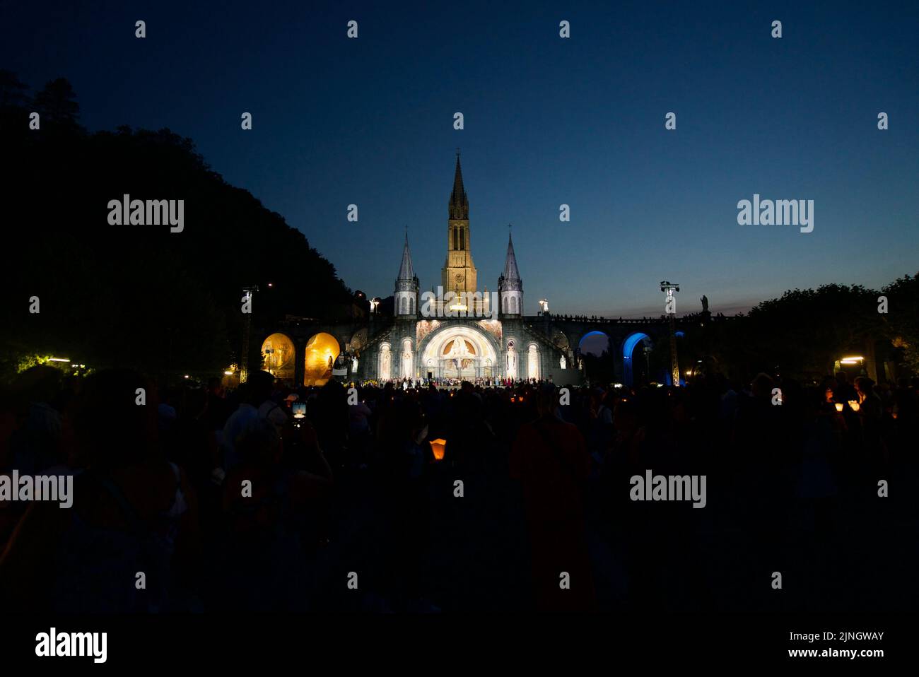 In der Nacht versammelten sich Menschen in Sanctuaires Notre-Dame de Lourdes. Ein katholischer Wallfahrtsort. Kerzenschein-Messe @ Wallfahrtskirche unserer Lieben Frau von Lourdes. Nacht. Stockfoto