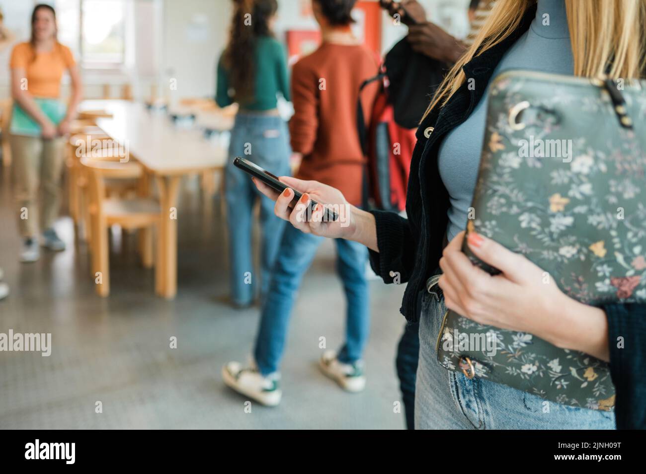 Schüler vor dem Unterricht mit dem Smartphone freistellen Stockfoto
