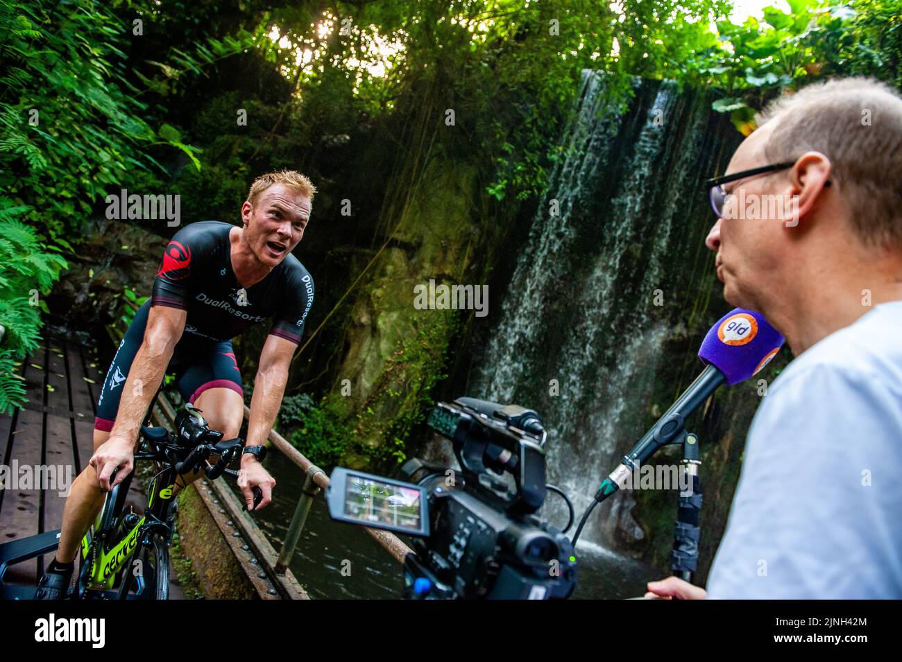 Arnhem, Niederlande. 11. August 2022. Ein Journalist hat während seines Trainings den Athleten Olaf Van Den Bergh interviewte. Der niederländische Spitzensportler Olaf Van Den Bergh beginnt im tropischen Regenwald des Burgers' Zoo in Arnhem zu trainieren, um sich auf die Ironman-Weltmeisterschaft in Kailua-Kona in Hawaii vorzubereiten. Der Bush (Indoor Tropical Rainforest) ist aufgrund der hohen Luftfeuchtigkeit und Temperatur der ideale Trainingsort. (Foto: Ana Fernandez/SOPA Images/Sipa USA) Quelle: SIPA USA/Alamy Live News Stockfoto