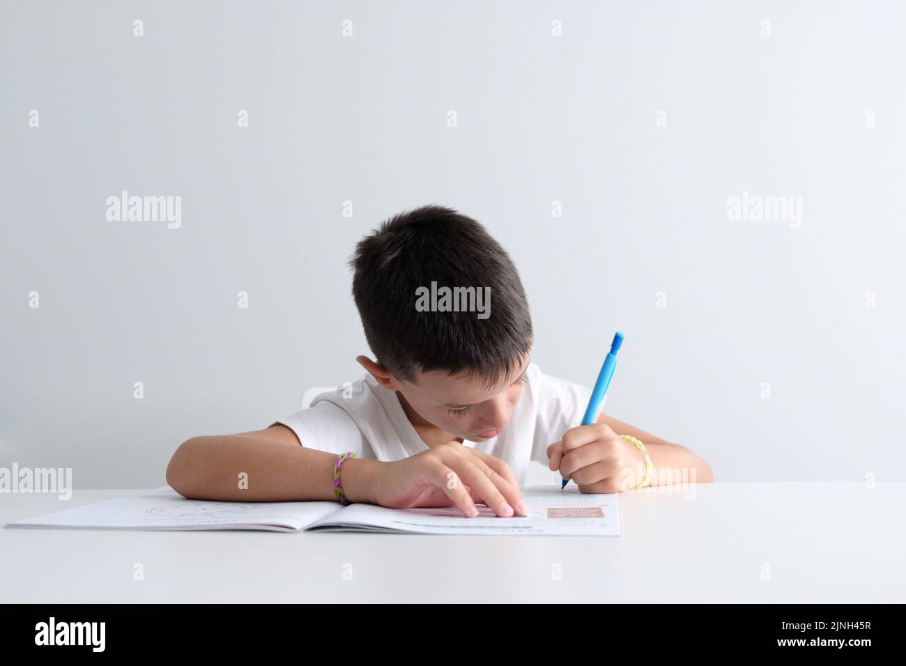 Kind, das zu Hause auf einem Schulbuch studiert. Die Konzentration der Kinder zu lernen Stockfoto