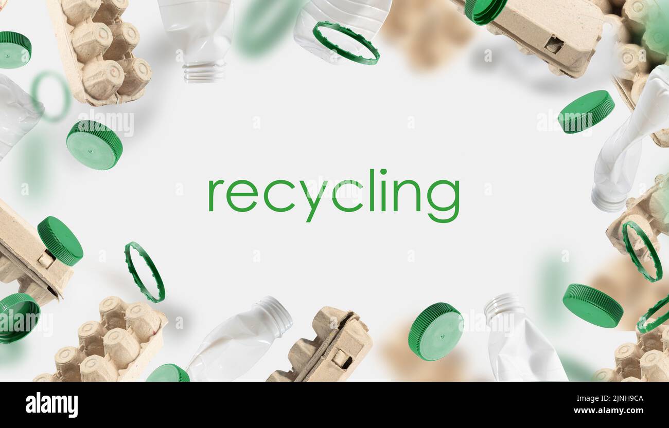 Eierkarton aus recyceltem Karton, Plastikflaschen und Flaschenverschlüsse auf grünem Hintergrund schwebt in der Luft. Recycling-Konzept aus Papier und Kunststoff. Stockfoto
