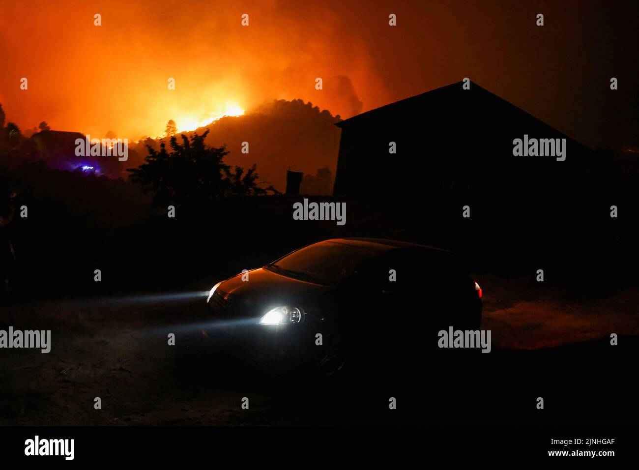 Ein Auto fährt von einem Waldbrand in Videmonte, Celorico da Beira, Portugal, 11. August 2022. REUTERS/Pedro Nunes Stockfoto