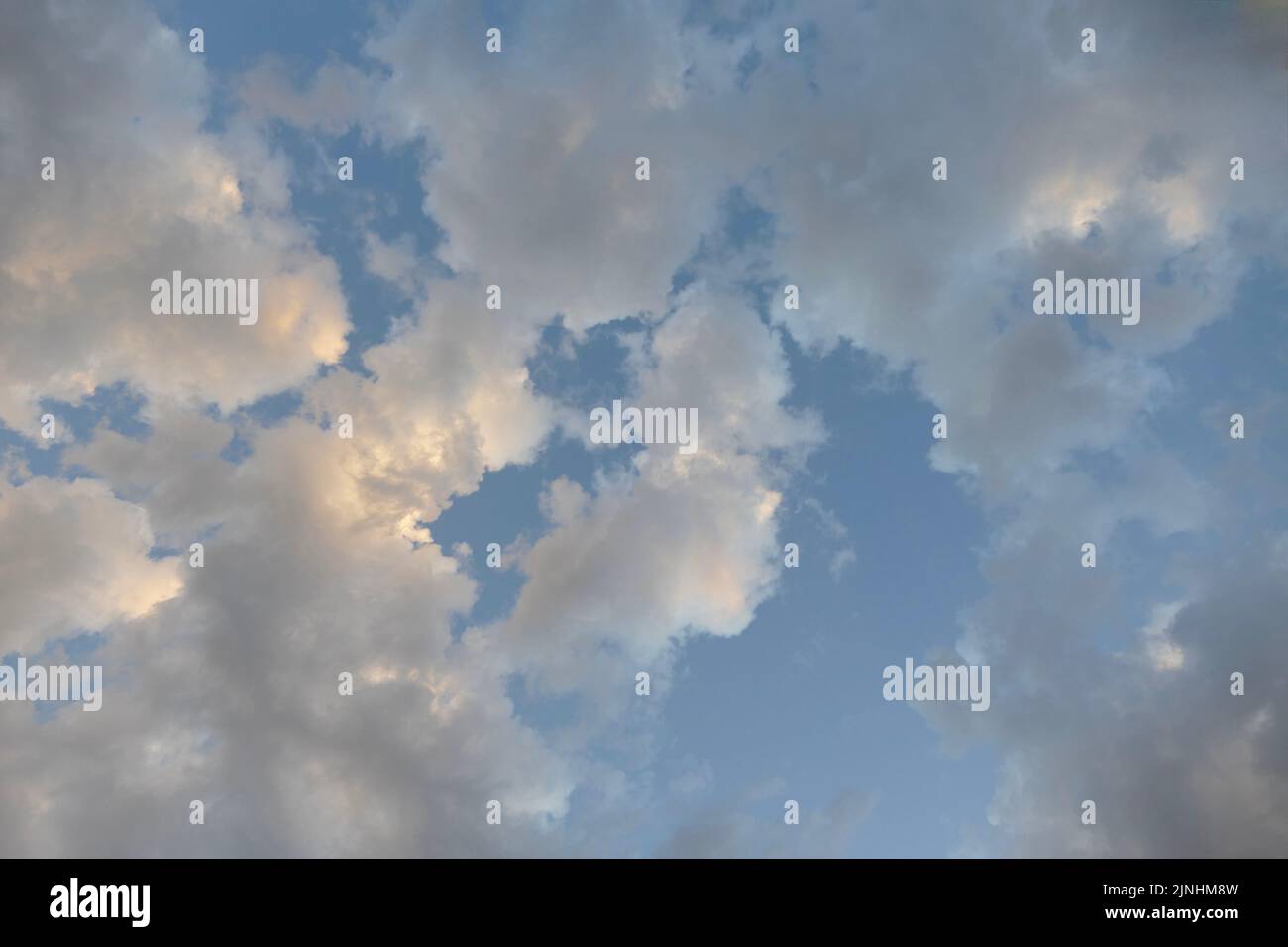 Bunte Kumuluswolken, die mit Sonnenlicht beleuchtet sind Stockfoto