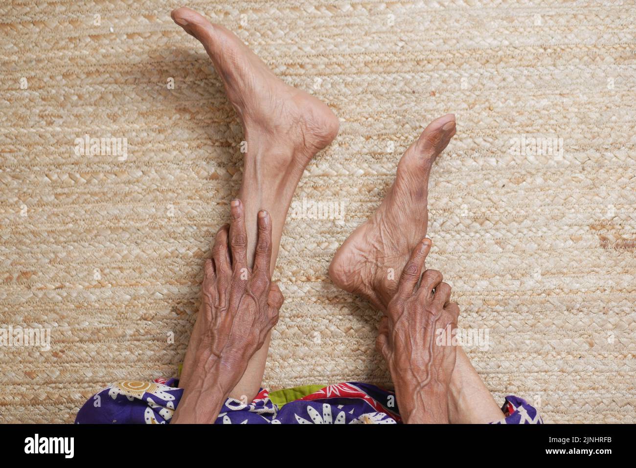 Ältere Frauen, Füße- und Handmassage an der Verletzungsstelle. Stockfoto