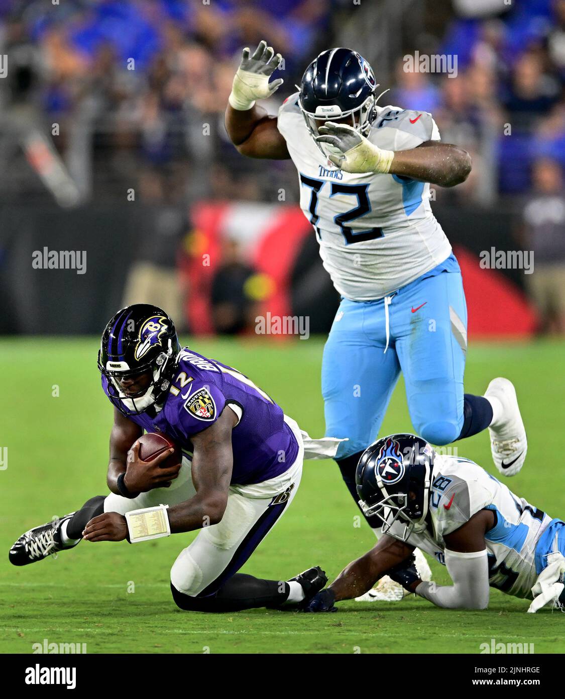 Baltimore, Usa. 11. August 2022. Baltimore Ravens Quarterback Anthony Brown (12) läuft am Donnerstag, den 11. August 2022, gegen die Tennessee Titans-Verteidiger Jayden Peevy (72) und Joshua Kalu (28) in der zweiten Hälfte eines Vorsaison-Spiels der NFL im M&T Bank Stadium in Baltimore, Maryland, zum ersten Mal. Baltimore besiegte Tennessee 23-10. Foto von David Tulis/UPI Credit: UPI/Alamy Live News Stockfoto