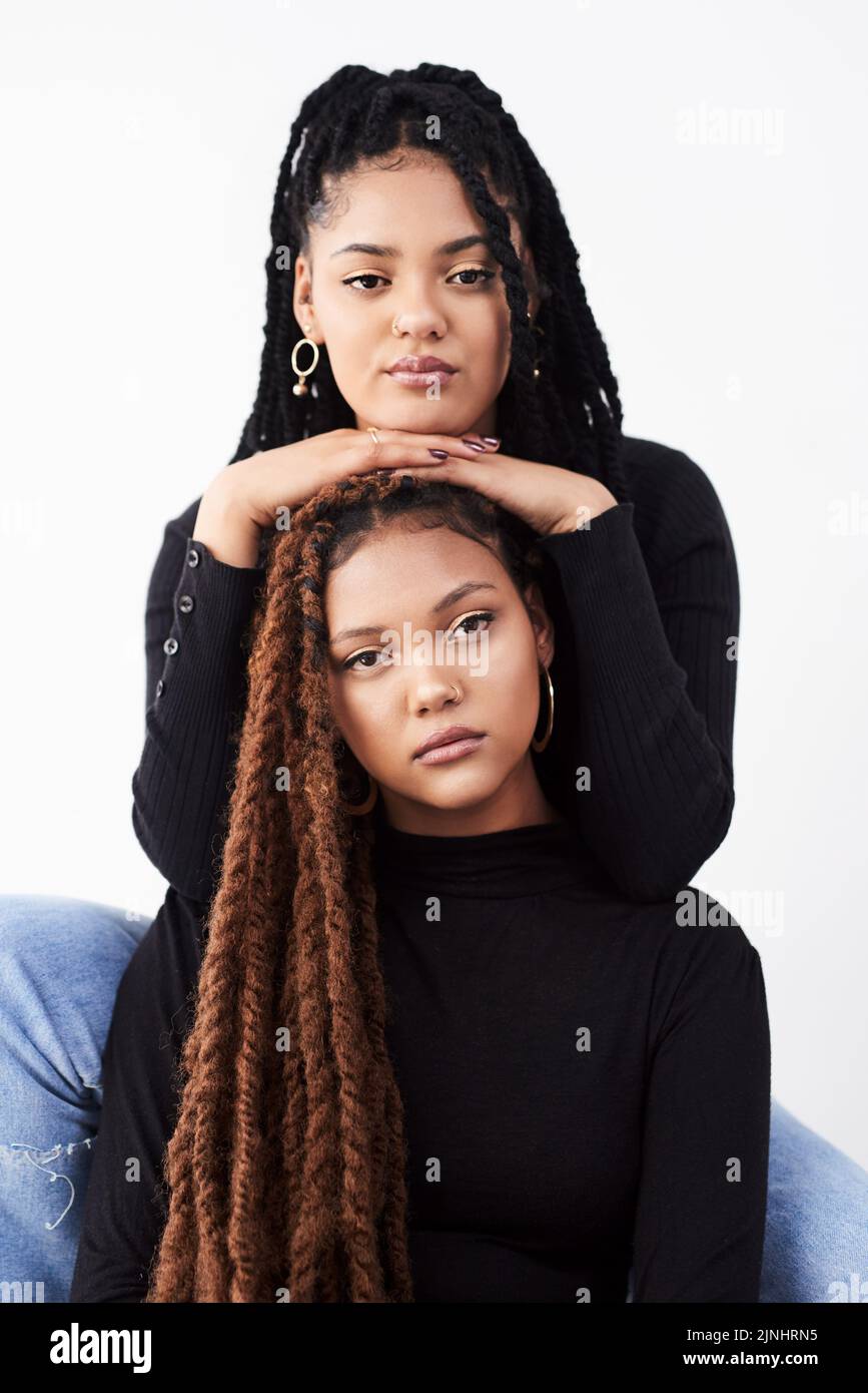 Natürliches Haar lässt Sie anhalten und starren. Studioaufnahme von zwei schönen jungen Frauen, die vor einem grauen Hintergrund posieren. Stockfoto