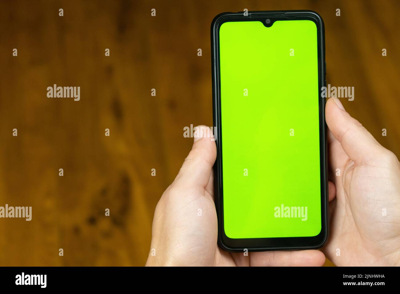 Grüne Chroma-Schlüsselhand mit Handy-Mockup-Muster... Stockfoto