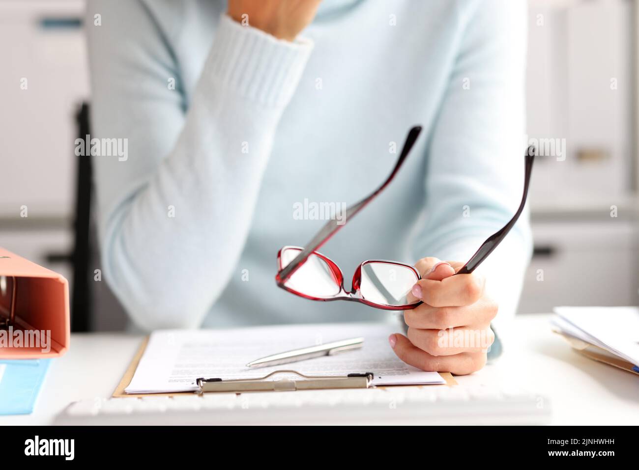Weibliche Büroleiterin, die am Arbeitsplatz mit Dokumenten arbeitet Stockfoto