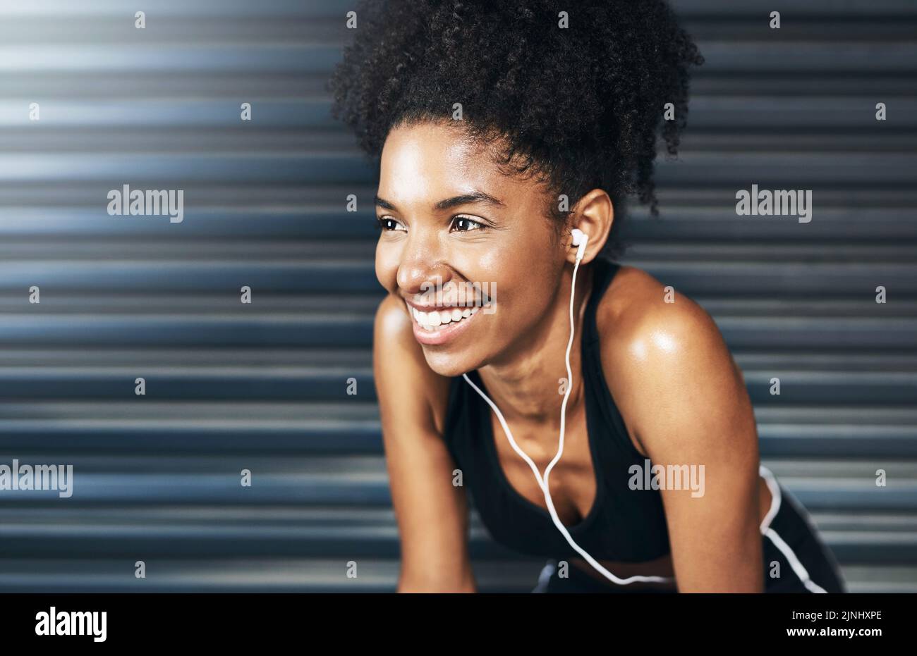 Jeder Tag ist eine neue Gelegenheit, sich zu verbessern. Eine sportliche junge Frau, die vor grauem Hintergrund eine Pause macht, während sie trainiert. Stockfoto