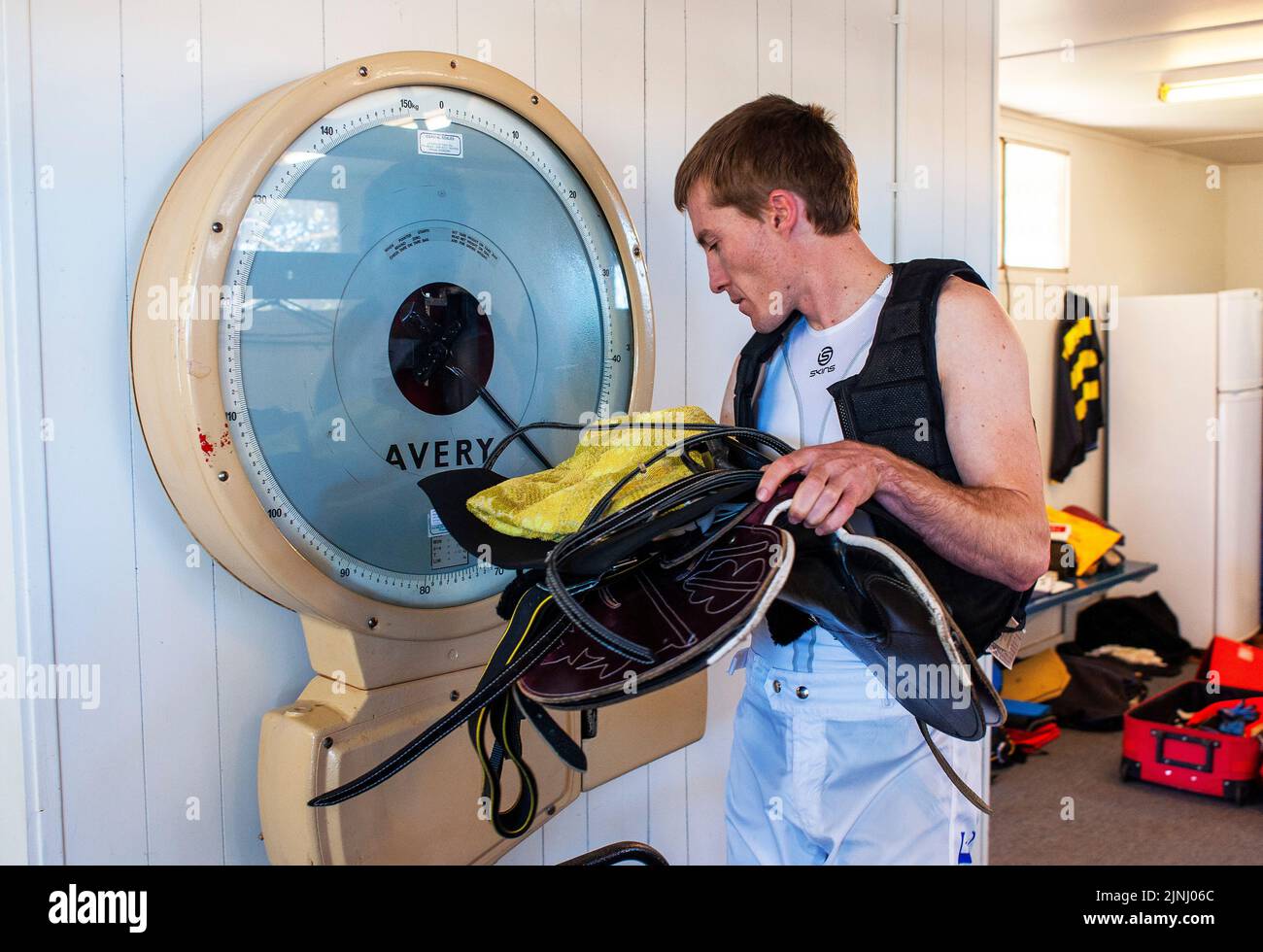 Ein Jockey mit Sattel wird vor einem Rennen im Kalgoorlie-Boulder Racing Club in Westaustralien abgewogen Stockfoto