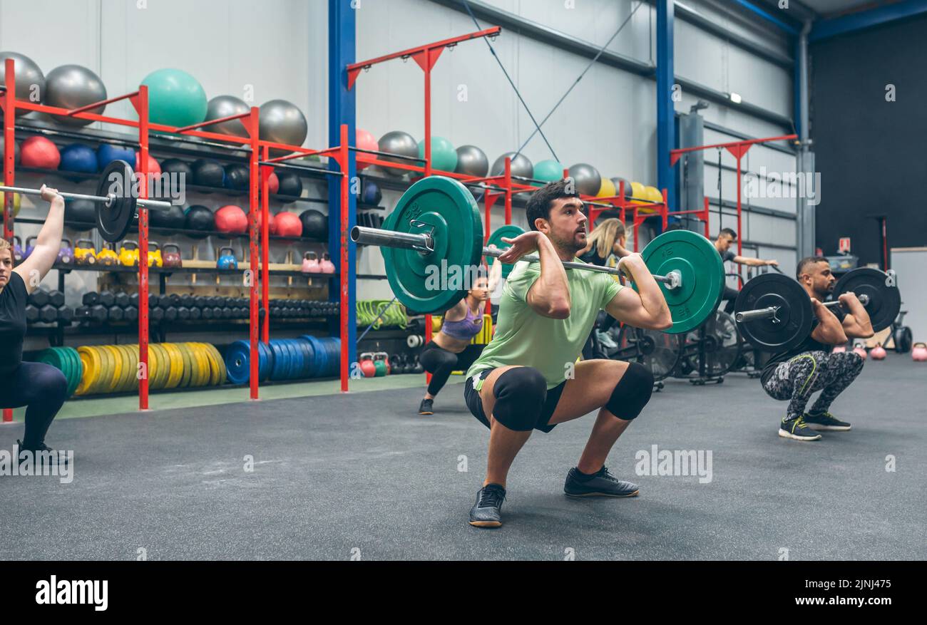 Menschen üben Gewichtheben in der Turnhalle Stockfoto