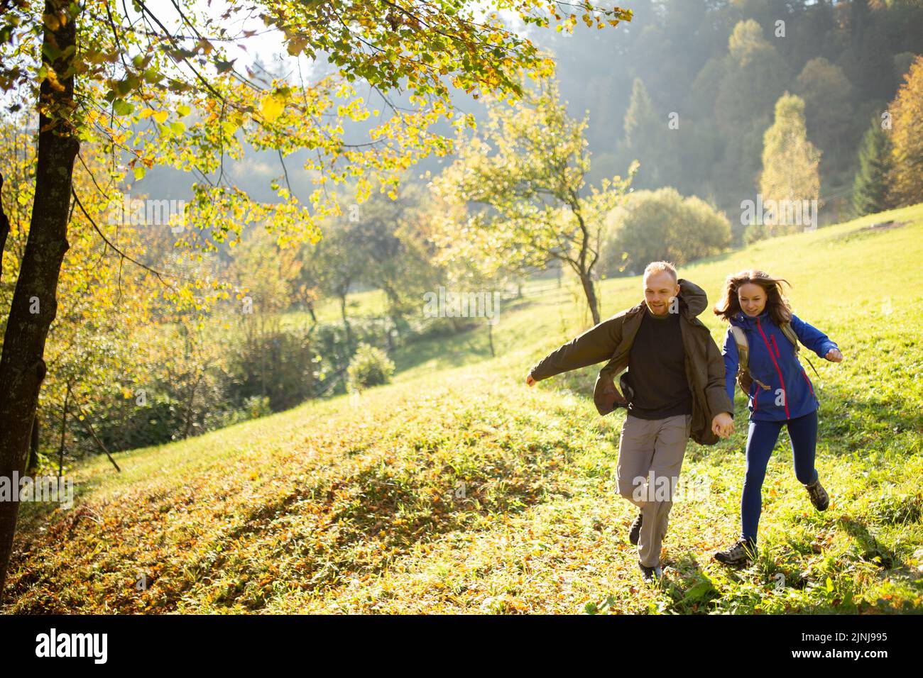 Weibliche und männliche junge aktive Wanderer haben Spaß und laufen mitten in den Bergen. Mann und Frau machten einen Ausflug in die Berge. Konzept des Abenteuers, tr Stockfoto