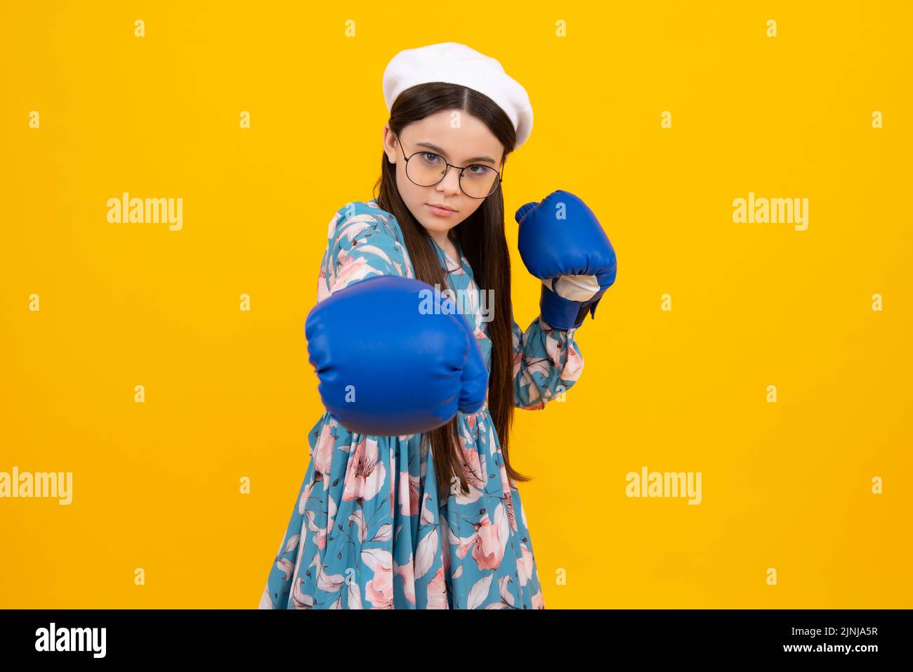 Porträt von lustig überrascht Sieger Teenager-Mädchen in Boxhandschuhen isoliert auf gelb. Kind in Boxhandschuhen. Stockfoto