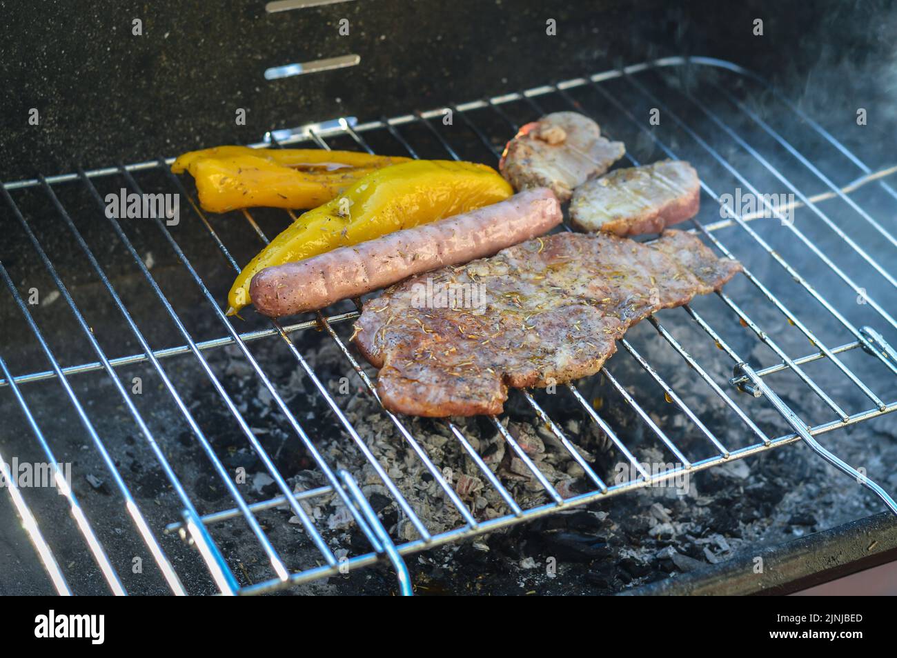 Grillen Sie mit Schweinefleisch und Paprika, die langsam ohne Flamme und ein wenig Rauch kochen Stockfoto