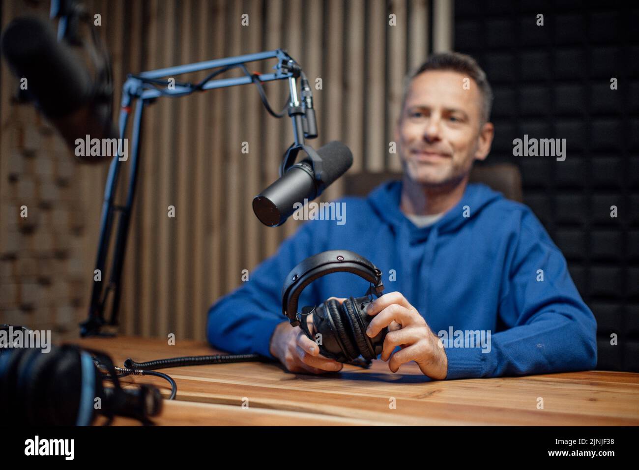 Porträt eines reifen Radiomoderaters, der im Mikrofon spricht und gleichzeitig eine Live-Show moderiert Stockfoto