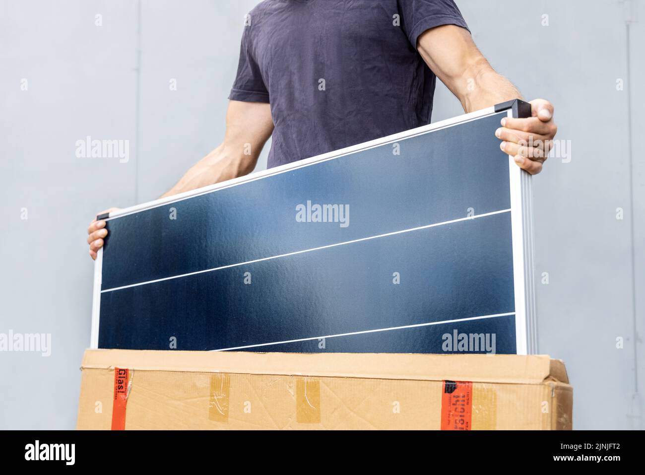 Person, die ein neues Solarpanel aus der Box nimmt Stockfoto