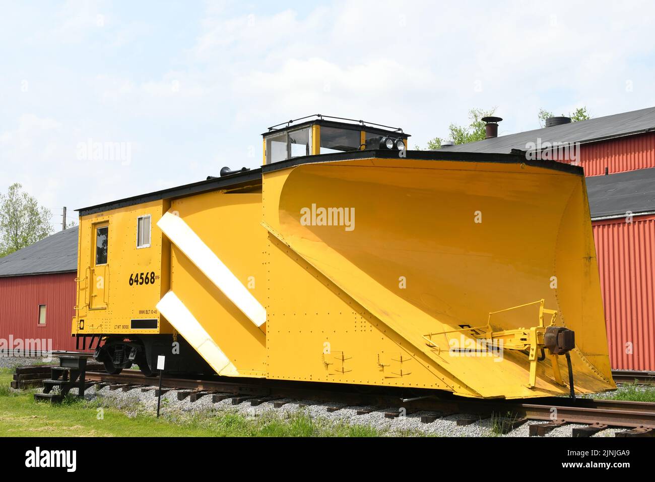 Ein antiker gelber Eisenbahnschneeplug auf den Schienen Stockfoto