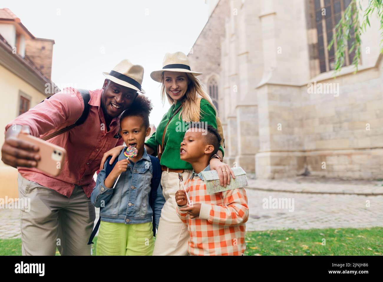 Multirassische Familie, die zusammen mit kleinen Kindern reist. Selfie in der Altstadt. Stockfoto