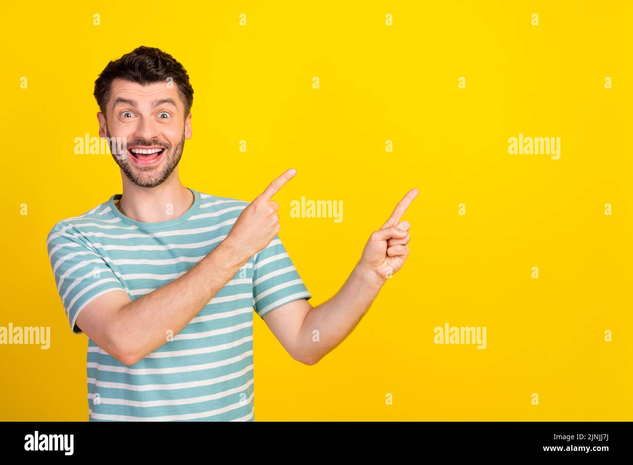 Portrait Foto von jungen attraktiven Kerl aufgeregt verrückt zeigen leeren Raum Werbung isoliert auf gelbem Hintergrund Stockfoto