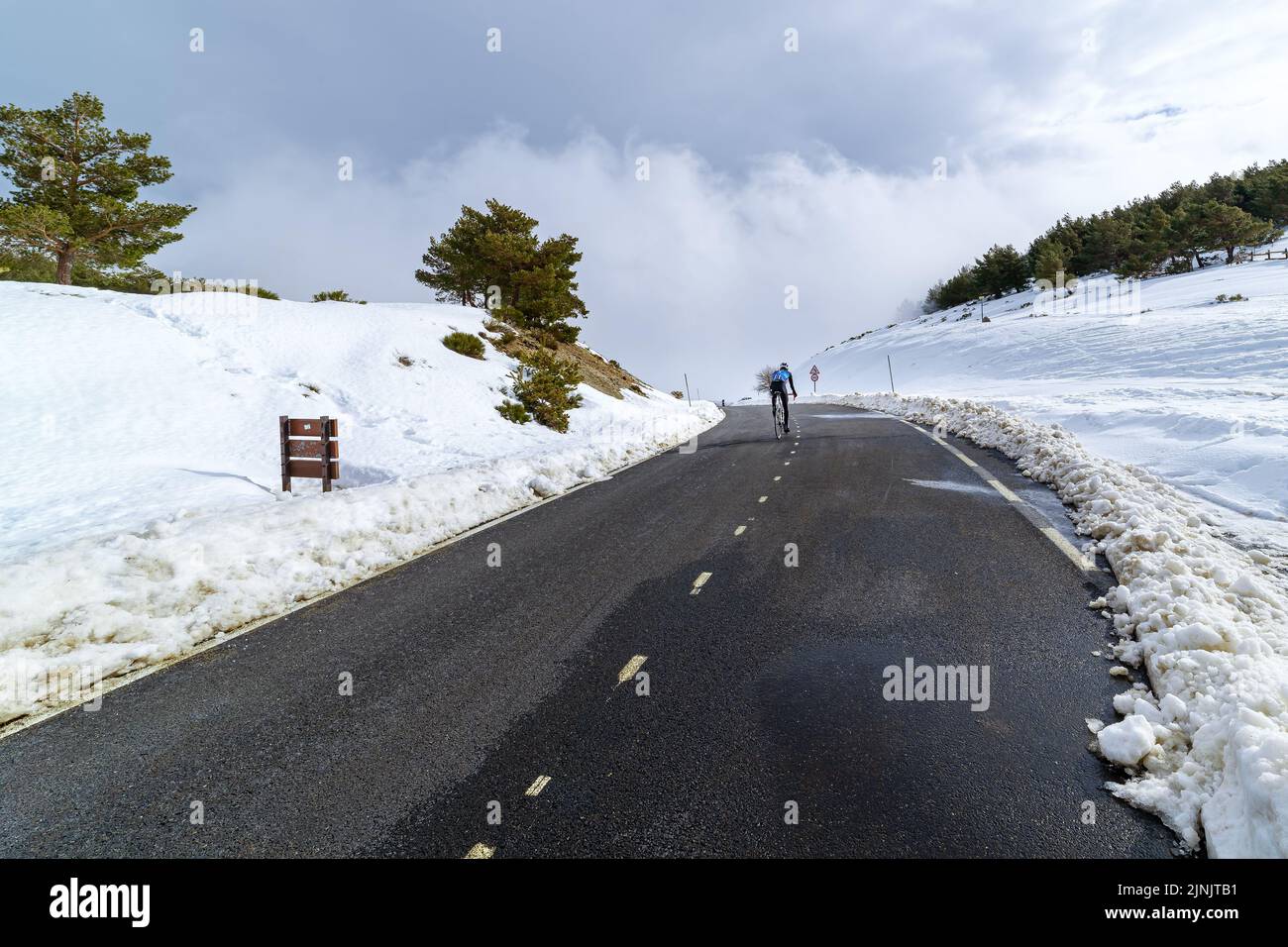 Radfahrer klettern verschneiten Hochgebirgspass. Stockfoto