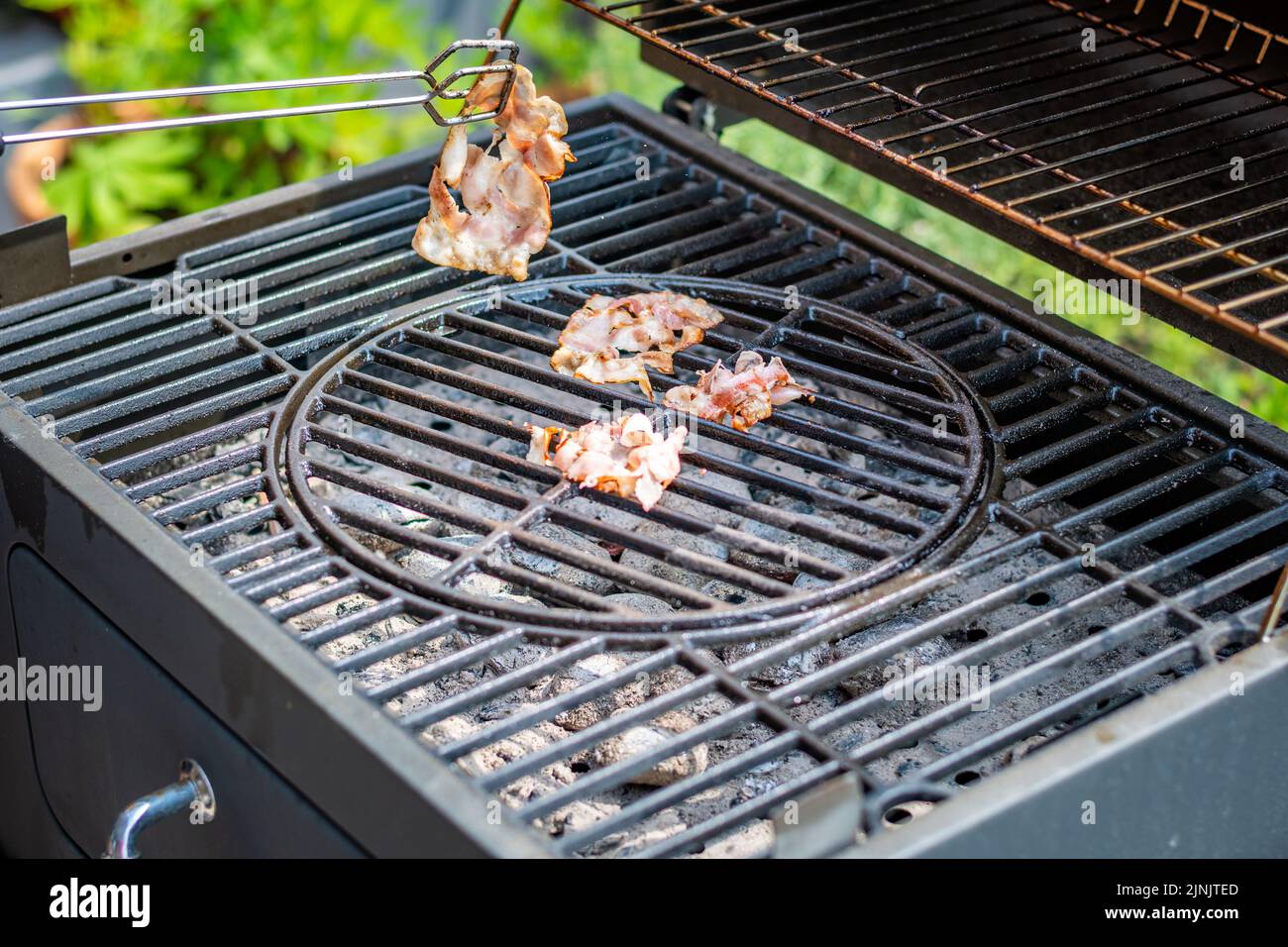 Speck Kochen auf dem heißen Grill, Vorbereitung von ungesunden Lebensmitteln. Stockfoto