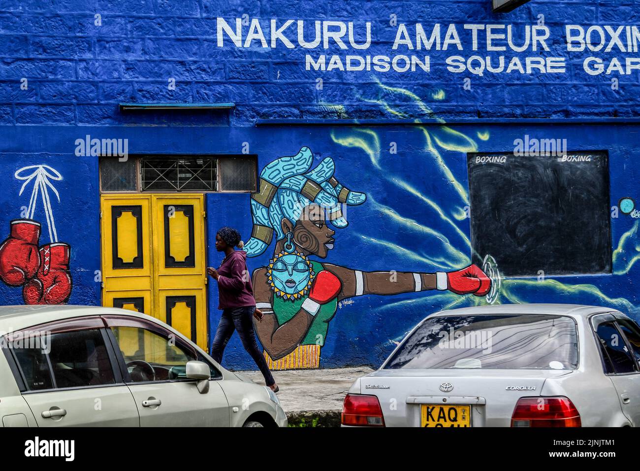 Eine Frau geht an einem Wandbild im Nakuru Amateur Boxing Club in Nakuru Town vorbei. Die Kenianer setzen ihre normalen Geschäfte fort, während sie warten, bis die endgültigen Ergebnisse der Präsidentschaftswahlen von der unabhängigen Wahlkommission des Landes bekannt gegeben werden. (Foto von James Wakibia / SOPA Images/Sipa USA) Stockfoto