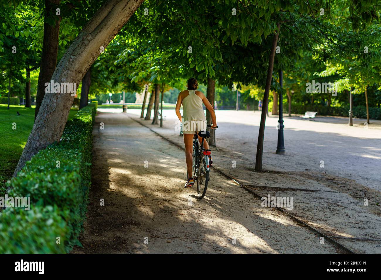 Retiro Park in Madrid an einem Sommertag bei Sonnenaufgang mit Menschen, die auf Fahrrädern Sport treiben. Stockfoto