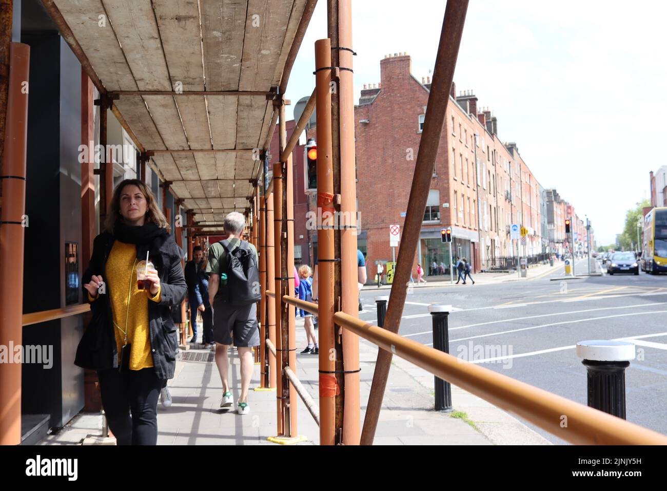 Ein Blick auf Fußgänger, die in Dublin City unter Gerüsten laufen Stockfoto
