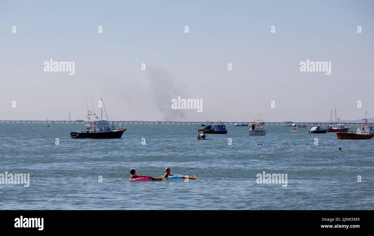 Grasbrand von Southend über die Themse mit kleinen Booten und dem Southend Pier im Mittelfeld. Hitzewelle im Sommer Stockfoto
