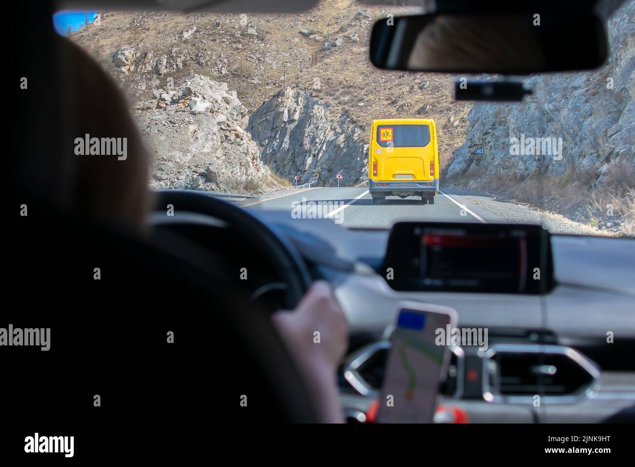 Benutzerdefinierte gelbe Kinder Taxi-Bus, der auf die Spitze eines felsigen Berges geht Stockfoto