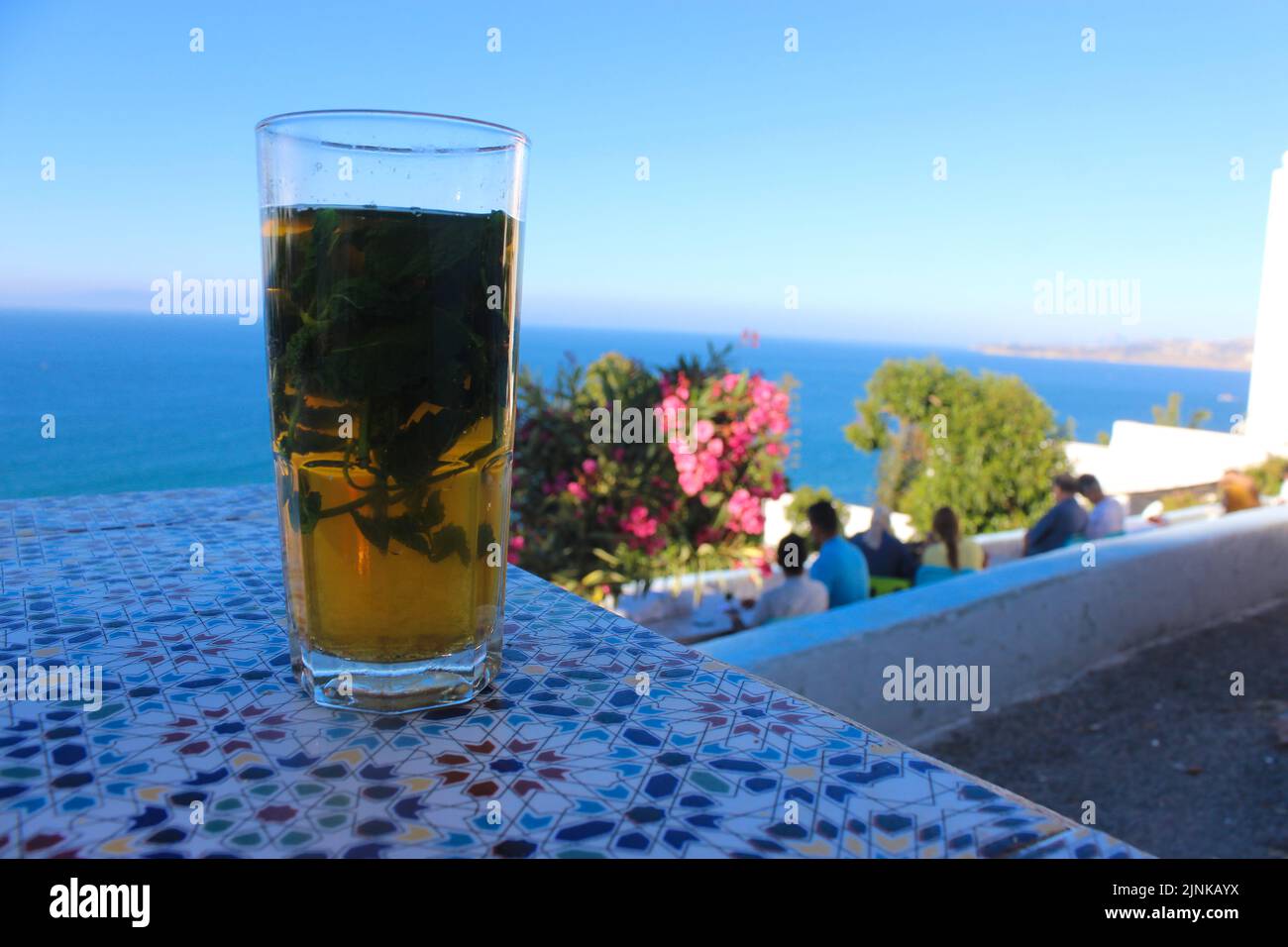 Eine Tasse marokkanischen Tee mit Minze auf einem zelligen Tisch in Tanger, Marokko Stockfoto