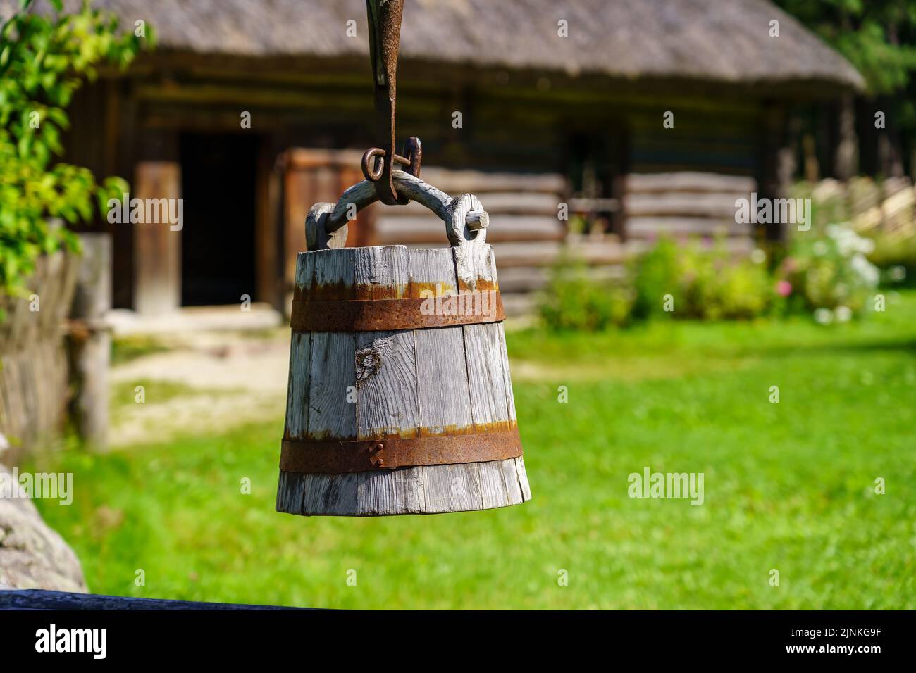 Alter Holzeimer, um Wasser aus dem Brunnen auf dem Feld zu ziehen. Stockfoto